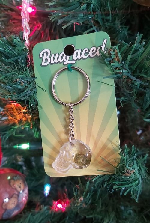 BudLaced keychain product sitting within foilage of Christmas tree.